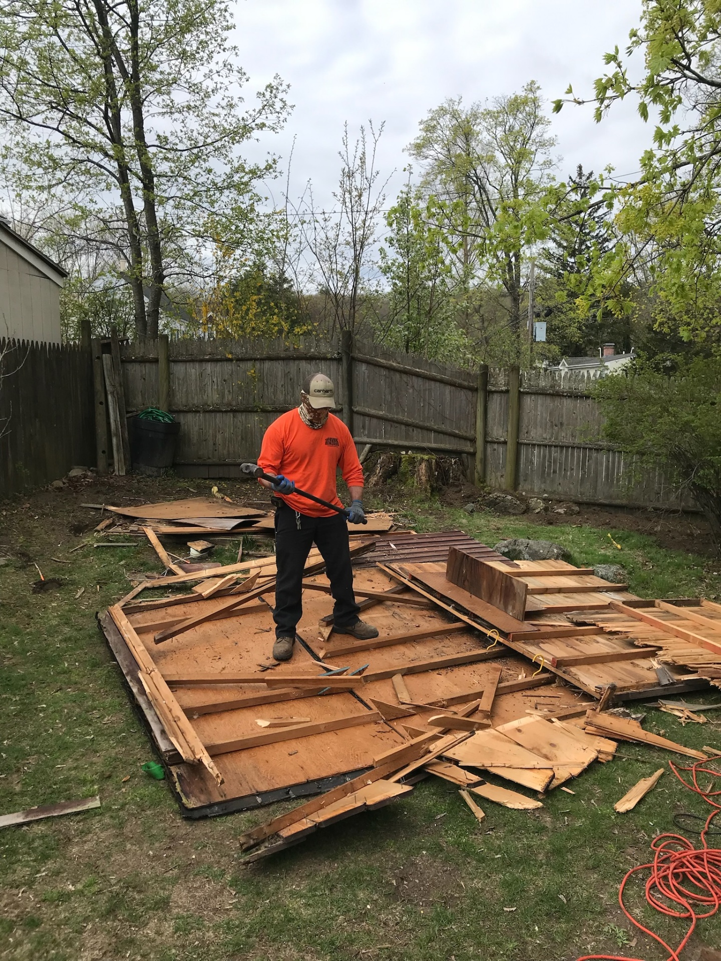 Crew member breaking down a backyard shed